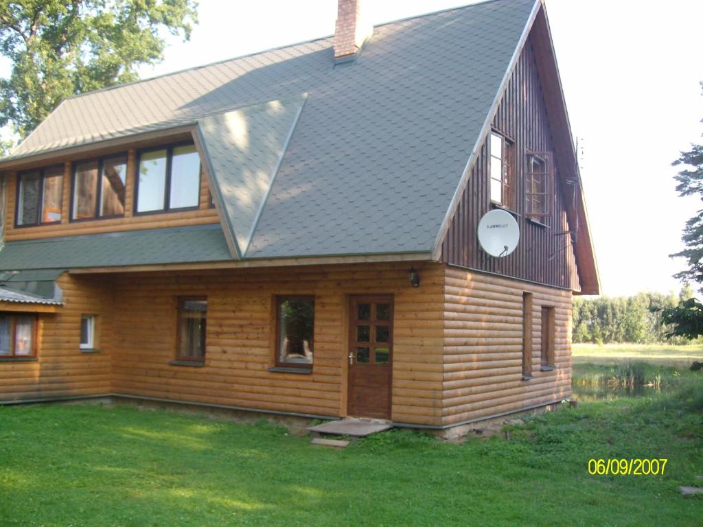 a house with a metal roof on top of it at Jāmaņi in Vigale