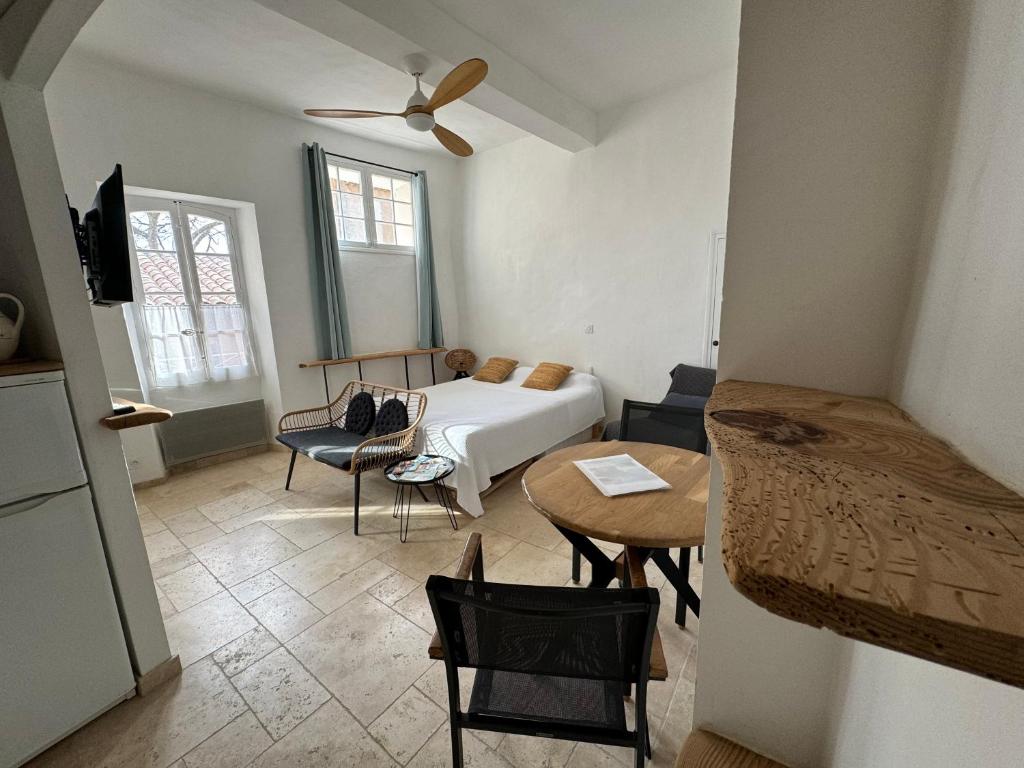 een kamer met een bed en een tafel en stoelen bij Studio 3 pers coeur de village Bormes les Mimosas in Bormes-les-Mimosas