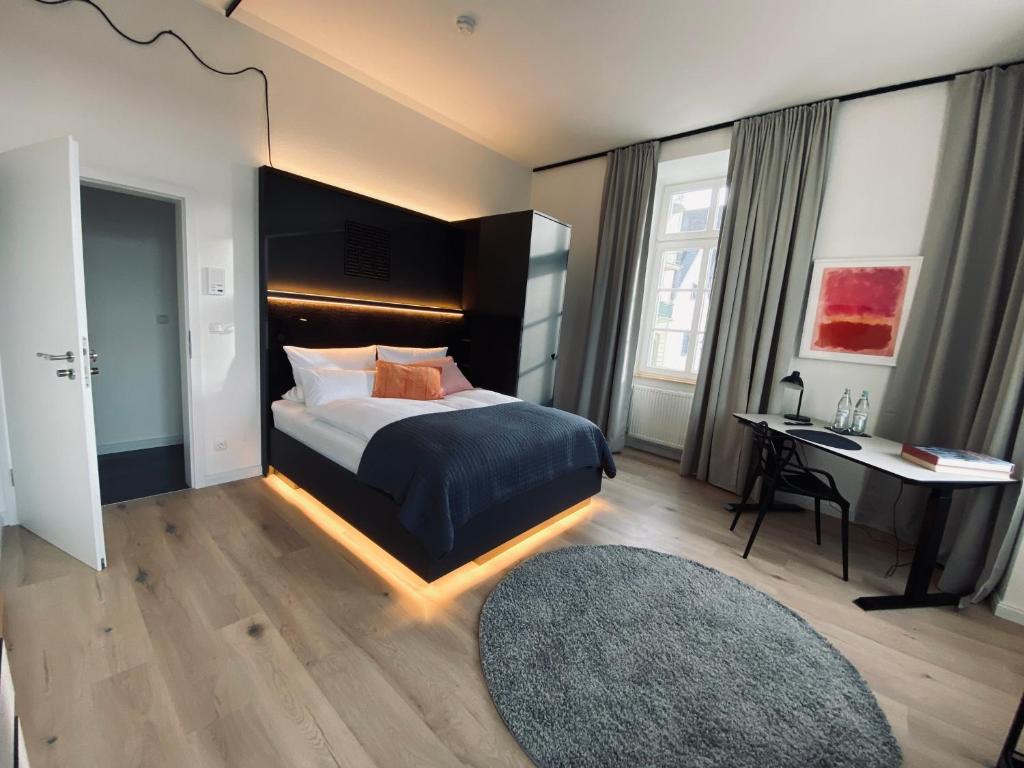 YokoLou - Design-Apartments في كوبلنز: غرفة نوم مع سرير مع مكتب وسرير سيد