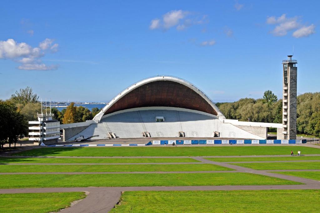 een groot gebouw met een dak op een grasveld bij Song Festival apartment, 5-10 min from bus/airport in Tallinn