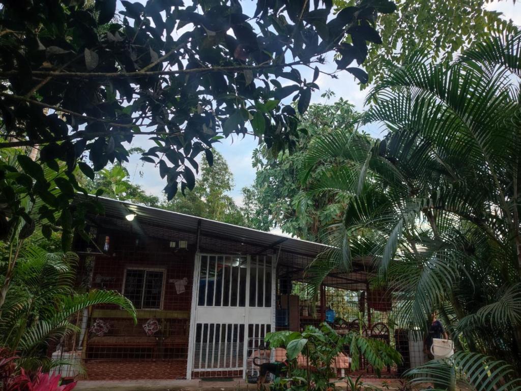 a house with a white door and some trees at Agradable granja cerca a un río de agua fresca. in Archidona