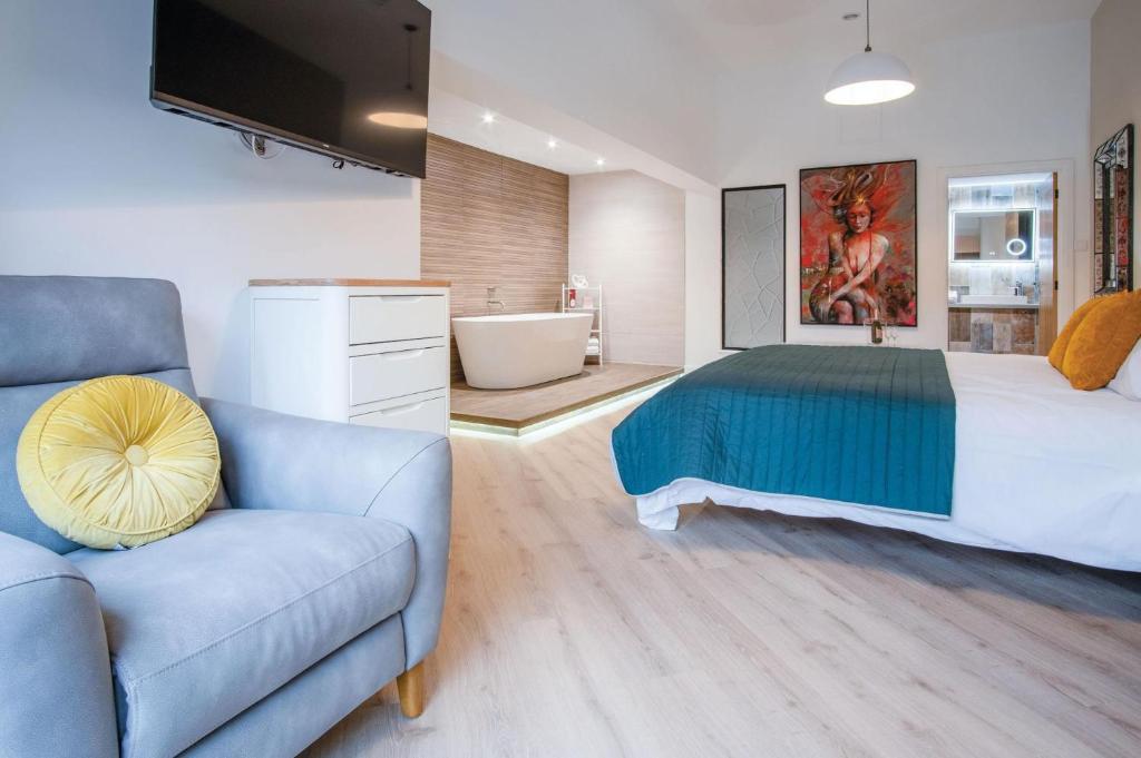 um quarto com uma cama, um sofá e uma banheira em Suite 5 - Sleeping Giant Hotel - Pen Y Cae Inn em Brecon
