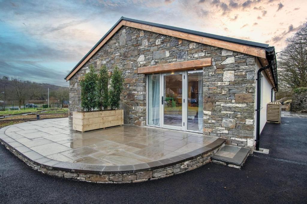 a small stone house with a circular patio at Suite 1 - Sleeping Giant Hotel - Pen Y Cae Inn in Brecon