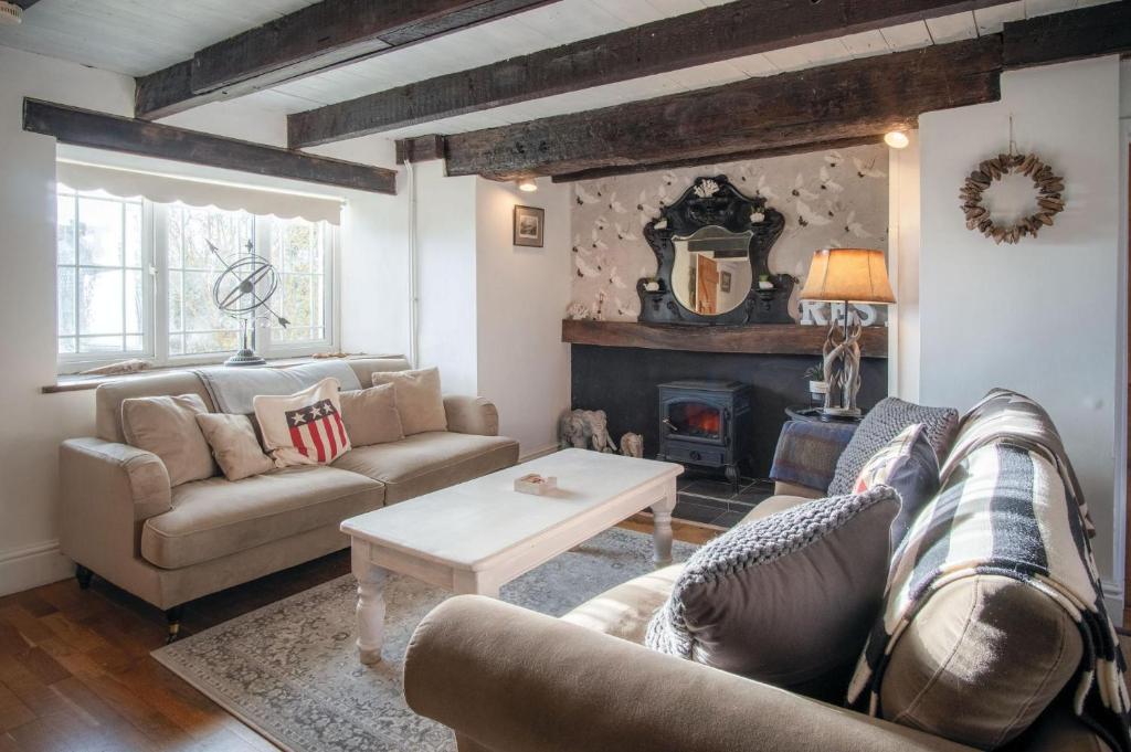 a living room with a couch and a fireplace at Milan Cottage - 2 Bedroom Cottage - Port Eynon in Port-Eynon