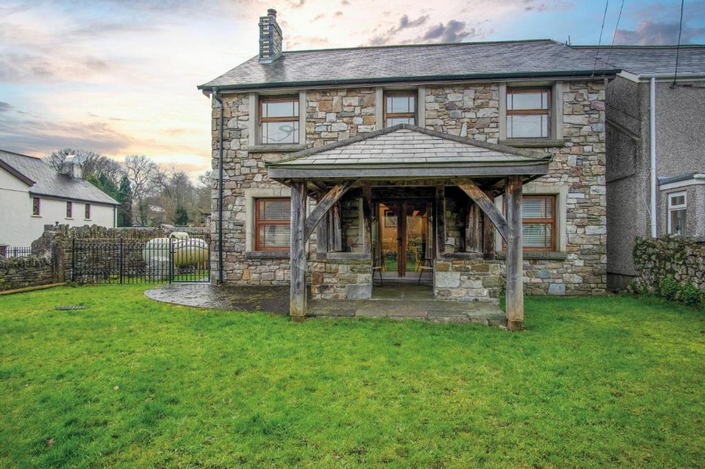 uma casa de pedra com um toldo no quintal em Oak Lodge - The Sleeping Giant - Pen Y Cae Inn em Brecon