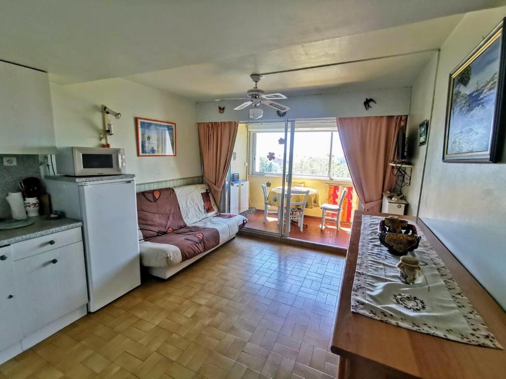 a kitchen and a living room with a couch at 001 Sentosa A15 in Cap d'Agde