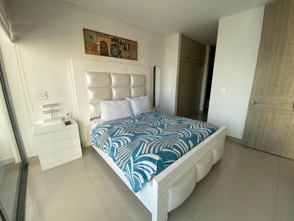 1 dormitorio con 1 cama con edredón azul y blanco en Apartamento piso 26 en Cartagena de Indias