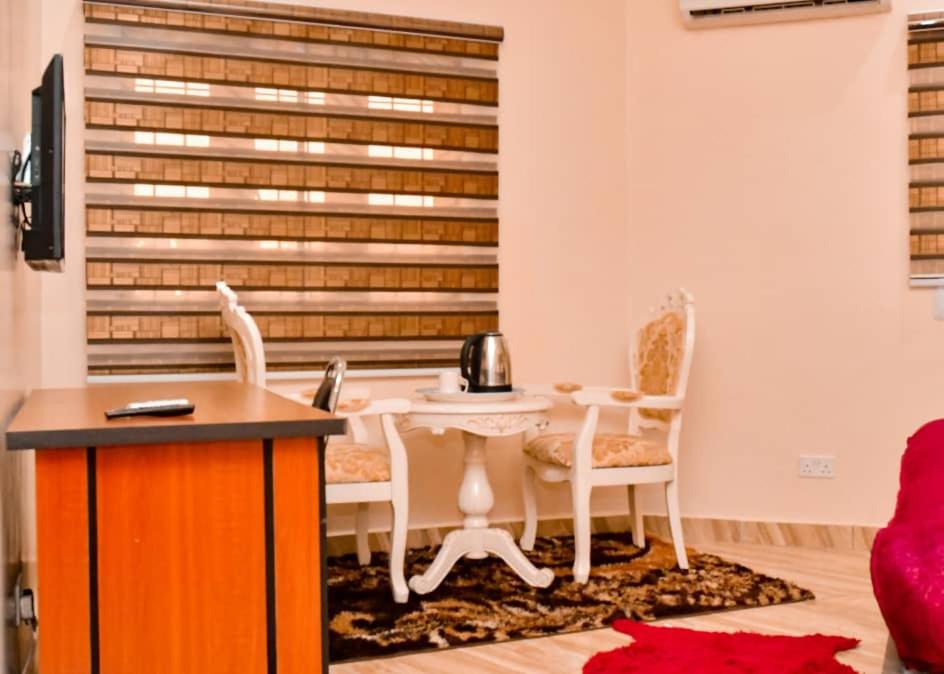 a room with a table and chairs and a telephone at Alim Royal Hotel and Suites in Abuja