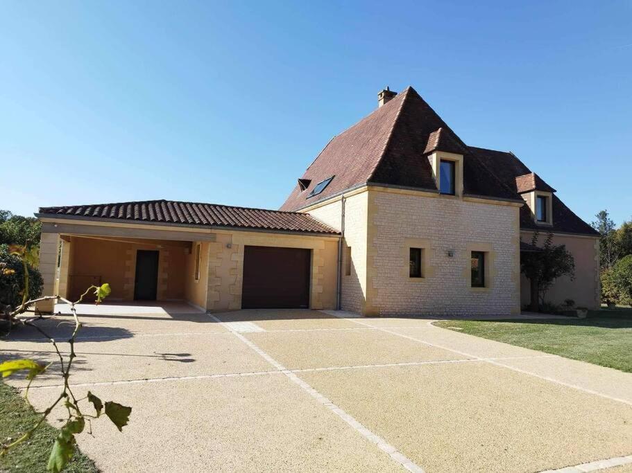 une grande maison blanche avec un grand garage dans l'établissement La jolie Villa du Pesquier, à Saint-Crépin-et-Carlucet