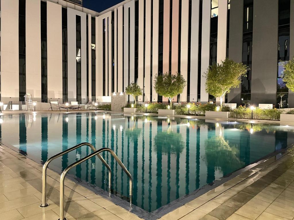 a swimming pool in front of a building at 45 Mins drive to Dubai Marina and The Beach at JBR in Sharjah