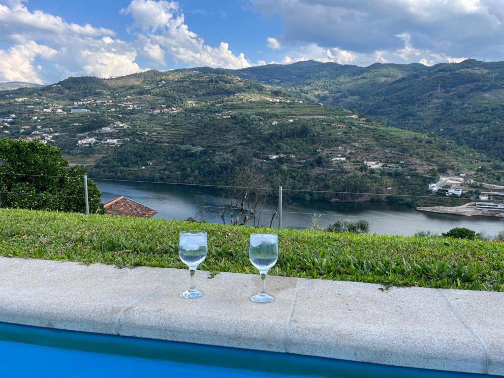バイアンにあるCasas do Casinhoto - Casa Vista Aregosの川を見下ろす棚に座るワイングラス2杯