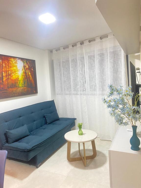 a blue couch in a living room with a table at Meireles Compact Apartamento 500m da praia in Fortaleza