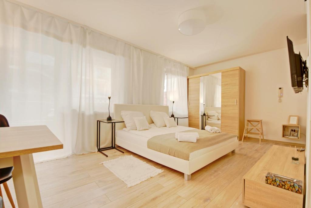 ジェシュフにあるApartament Rochaの白いベッドルーム(ベッド1台、テレビ付)