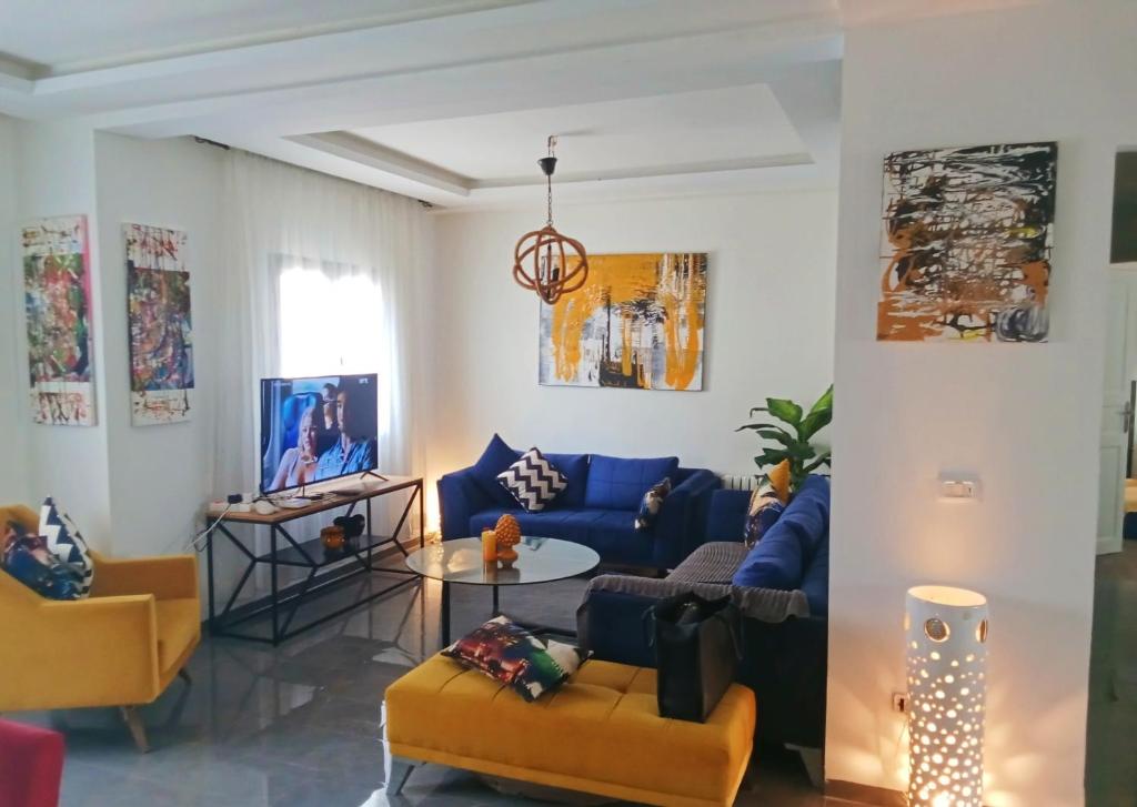 a living room with blue and yellow furniture at MAISON JOE in Gammarth