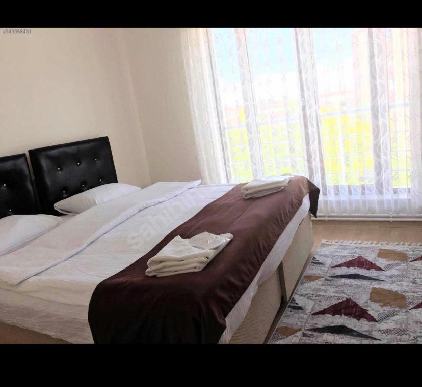 a bedroom with a bed with two towels on it at WHİTE SUİT in Sulusaray