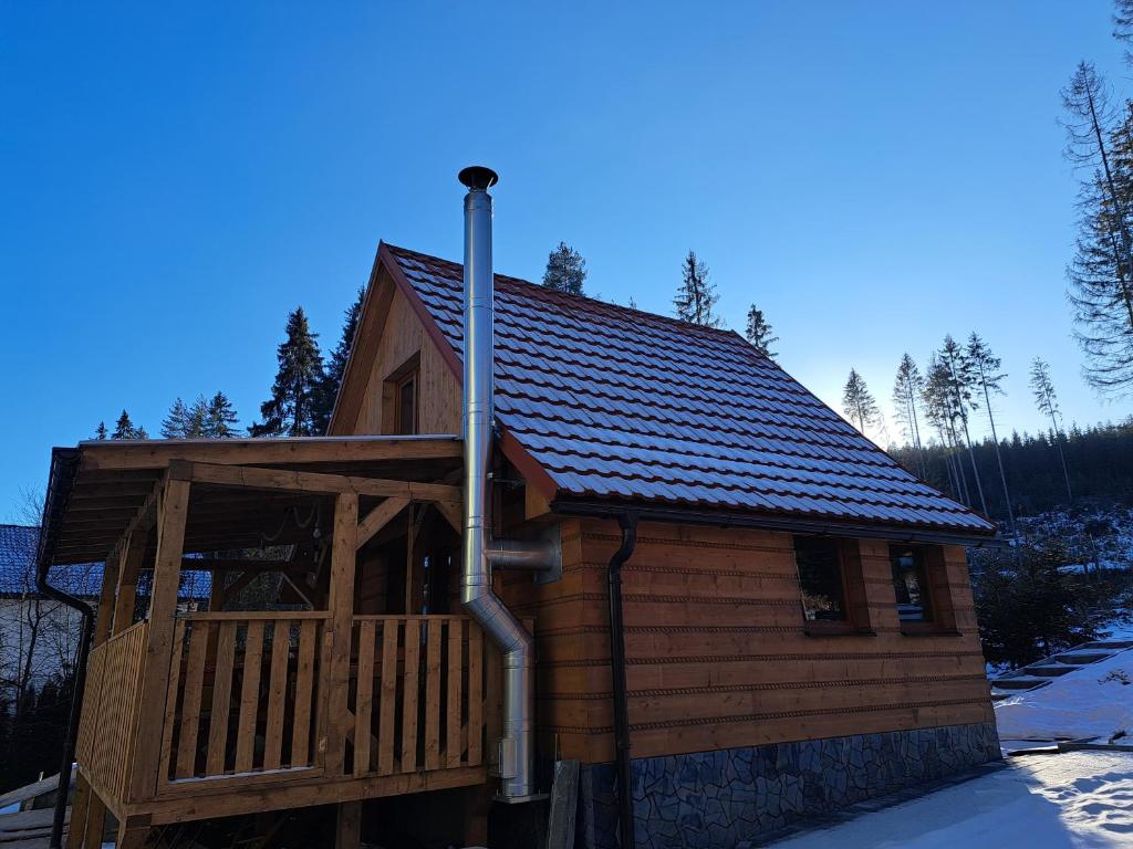 a large wooden cabin with a metal roof at Chata TRI GROŠE 2 in Námestovo