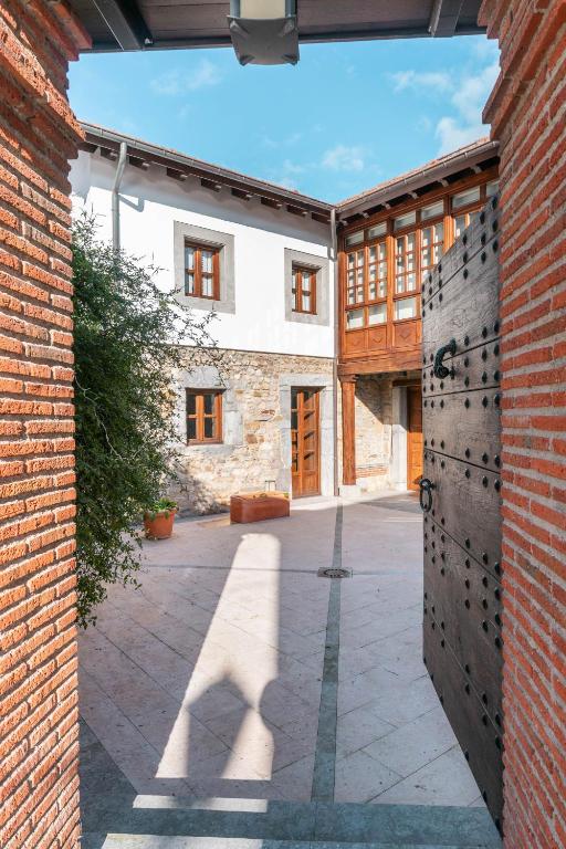 an external view of a brick building with a gate at LA CASA DE LA RIBA in Luanco