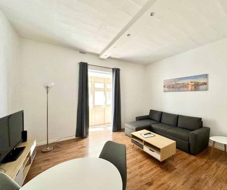 a living room with a couch and a table at Central and modern Valletta flat in Valletta