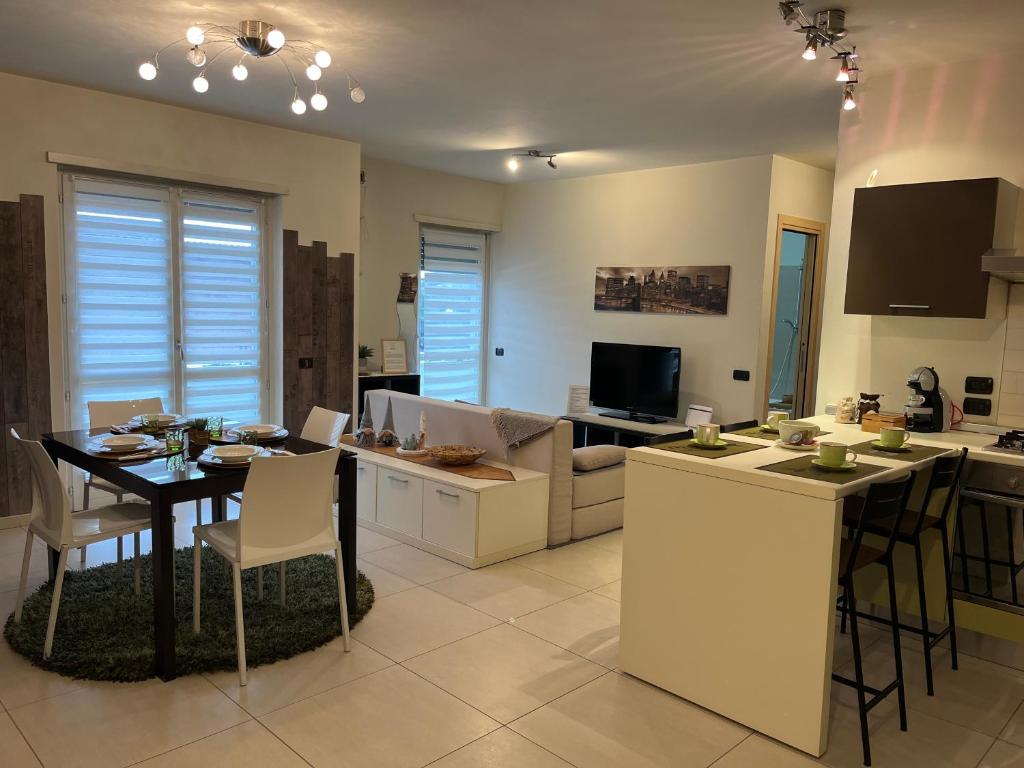una cucina e un soggiorno con tavolo da pranzo, tavolo e sedie di Apartamento da Jenny ad Aosta