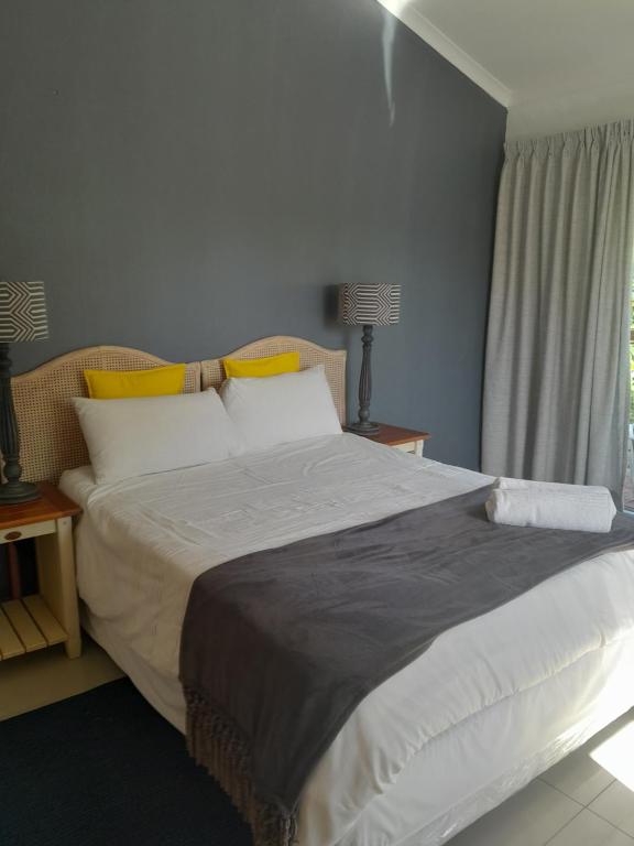 a large bed in a bedroom with a window at INDABA MANOR ON OWEN ELLIS DR in Port Edward