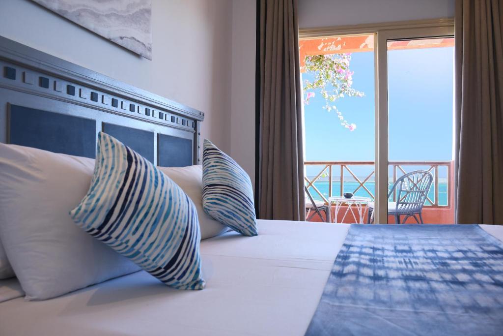 a bedroom with a bed with a view of the ocean at SOULOTEL EMERALD Resort & Spa in Marsa Alam City