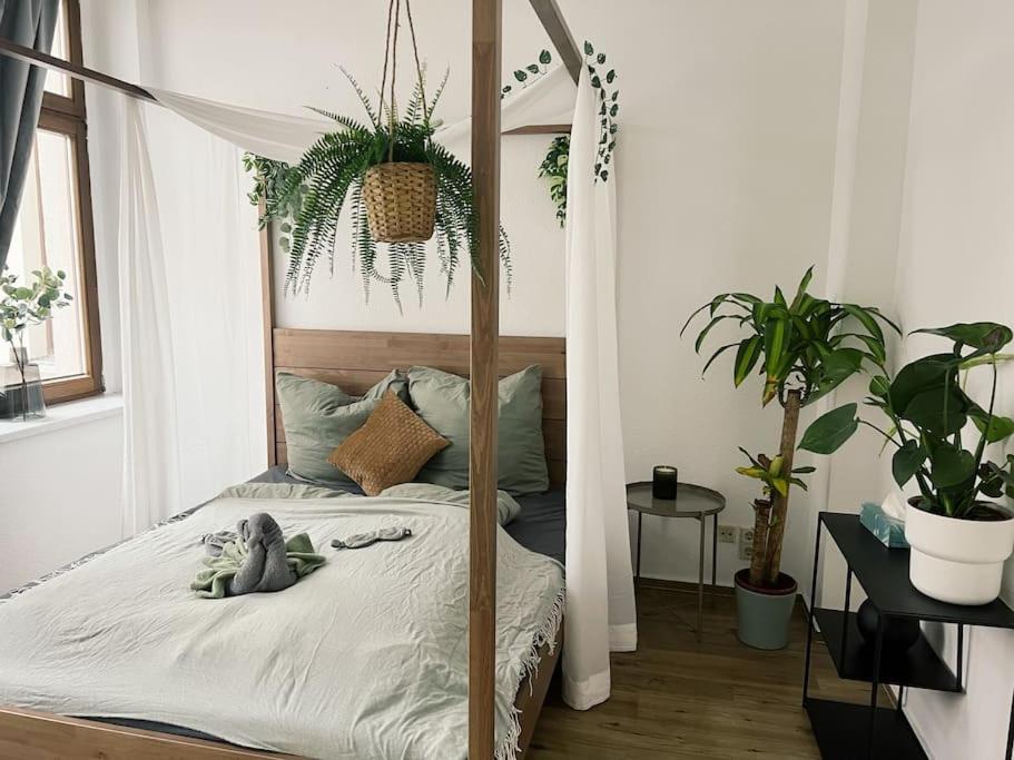 ein Schlafzimmer mit einem Himmelbett mit Pflanzen in der Unterkunft Pretty Home City Jungle in Zwickau