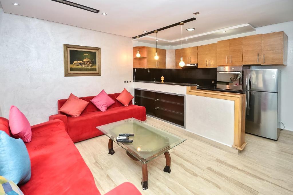 sala de estar con sofá rojo y cocina en Sunny Modern 1BR in Belvedere en Casablanca