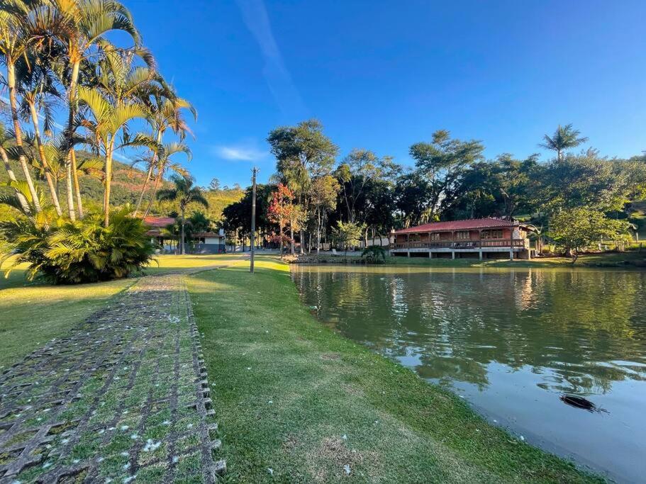 a park with a lake and a building and palm trees at Cabana Exclusiva: Recarregue suas Energias in Camboriú