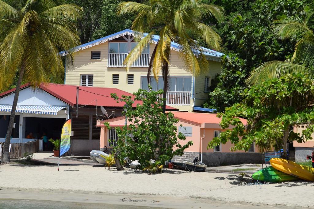 une maison sur la plage avec des palmiers dans l'établissement Meublé 8 Couchages Bord De Mer, à Les Anses-d'Arlet