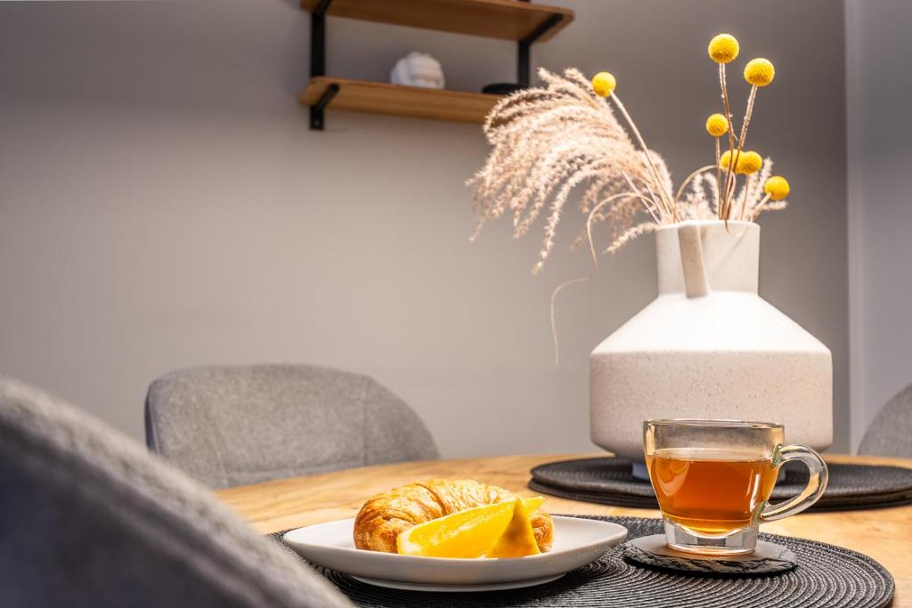 a table with a cup of tea and a plate of food at HYGGE: Design Apartment - 6 Personen - Zentral in Elmshorn