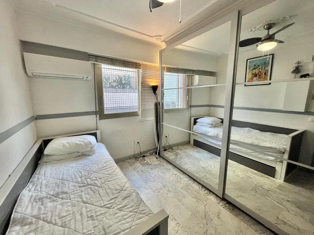 Cette petite chambre comprend 2 lits et un miroir. dans l'établissement Minerve by Welcome to Cannes, à Cannes