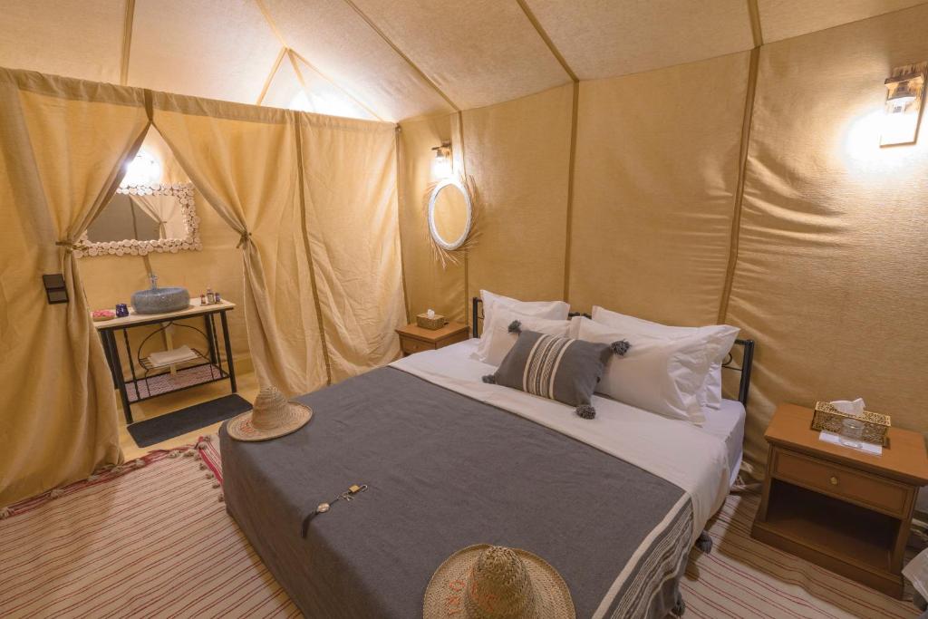 a bedroom with a bed in a tent at Merzouga Heart Luxury Camp in Merzouga