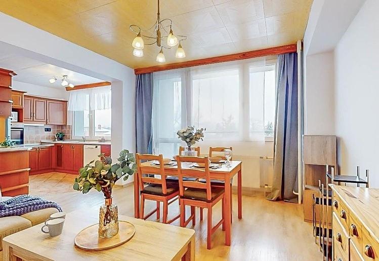 kuchnia i salon ze stołem i krzesłami w obiekcie Apartment in center of Poděbrady w Podiebradach