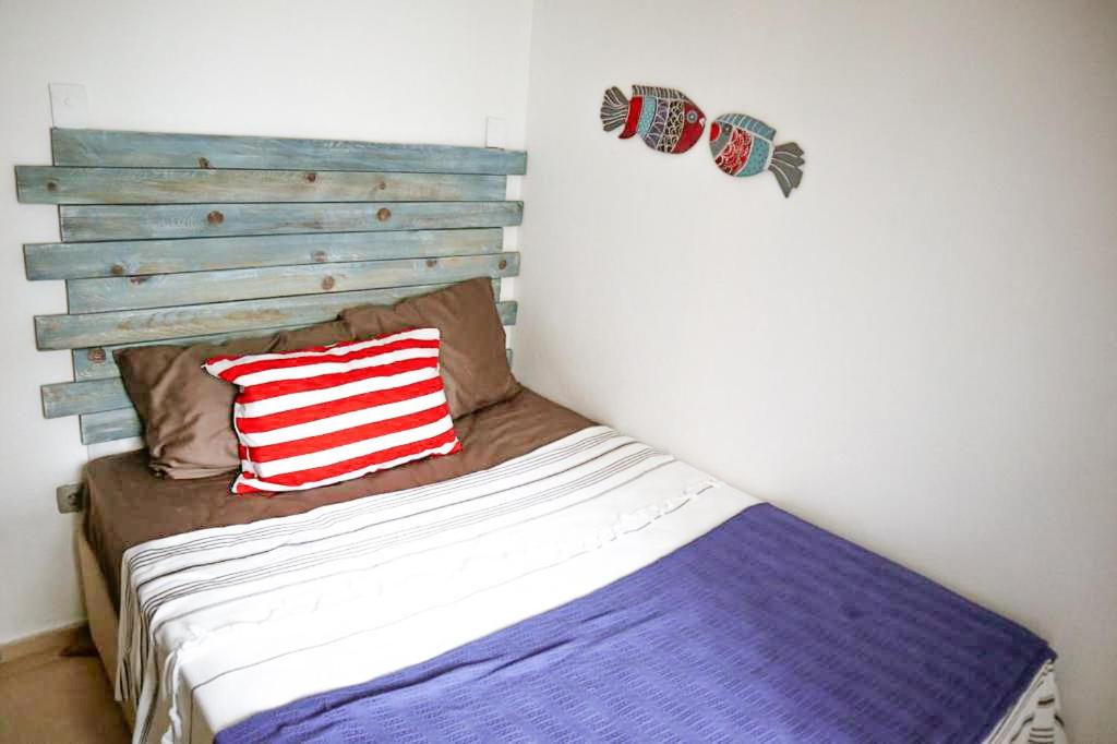 a bedroom with a bed with a wooden headboard at Mandalin Apart 