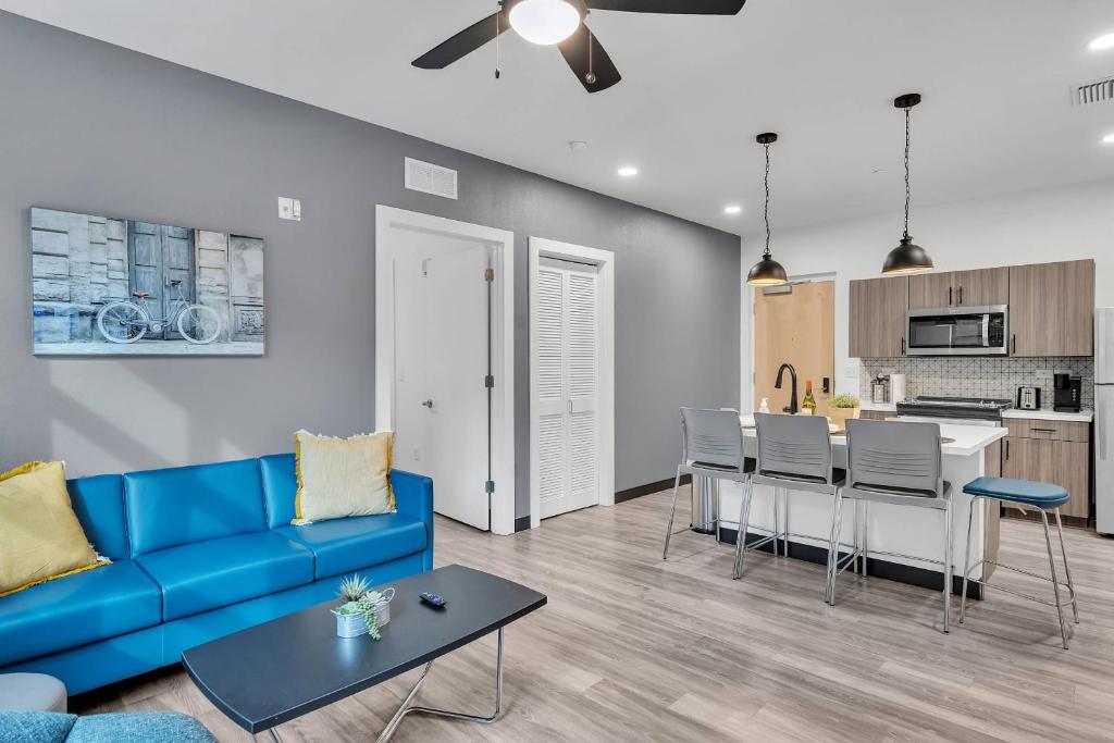 a living room with a blue couch and a kitchen at The Well 104 in Zephyrhills