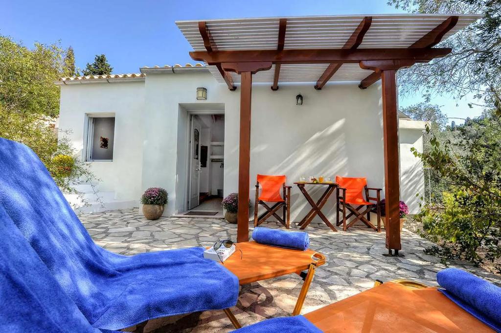 une terrasse avec des chaises bleues et une table en bois dans l'établissement Aimilia Cottage, à Longós