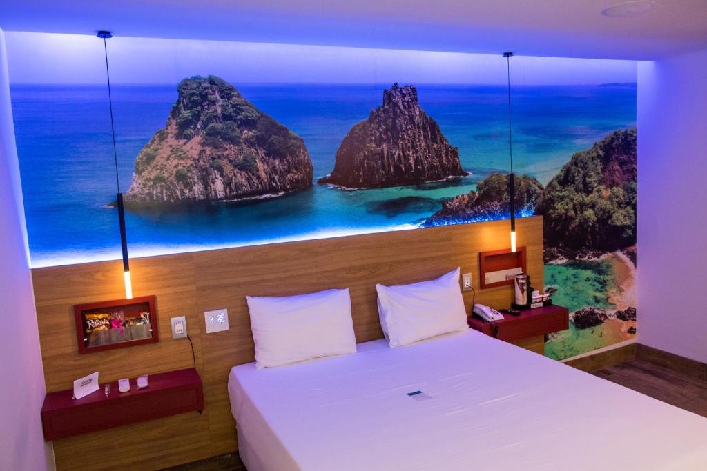 a bedroom with a bed with a view of the ocean at Suítes Alvorada in Rio Verde