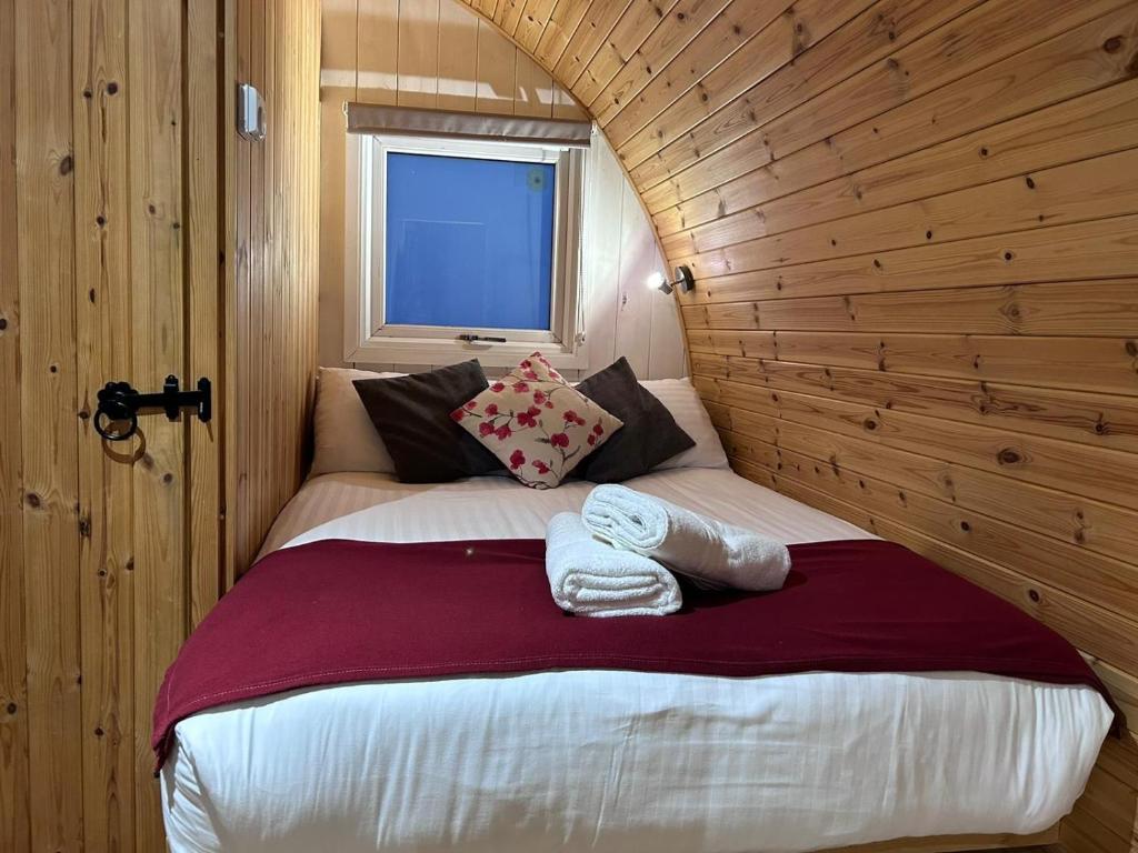 a bedroom with a large bed in a wooden wall at Mounatian Edge Resort Mega pod 6 in Church Stretton