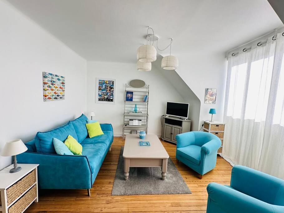 een woonkamer met een blauwe bank en een tafel bij Cosy appartement - Hypercentre in Lorient