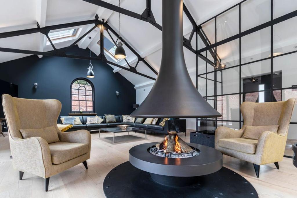 a living room with a fireplace and two chairs at SandiComplex - 2 properties joined by a garden gate in Sandwich