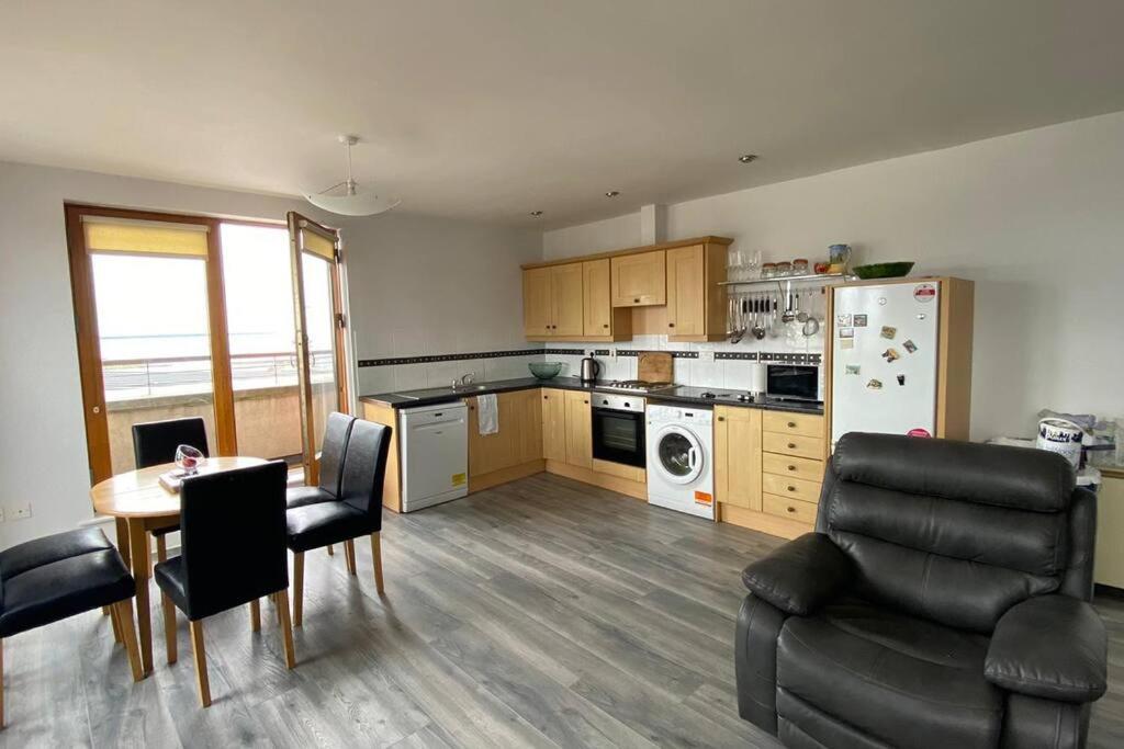 uma cozinha com mesa e cadeiras e uma sala de jantar em Vera’s Penthouse em Wexford