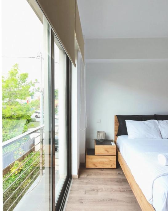 a bedroom with a bed and a large window at Cozy & Minimal Apartment Near Airport Peania in Paianía