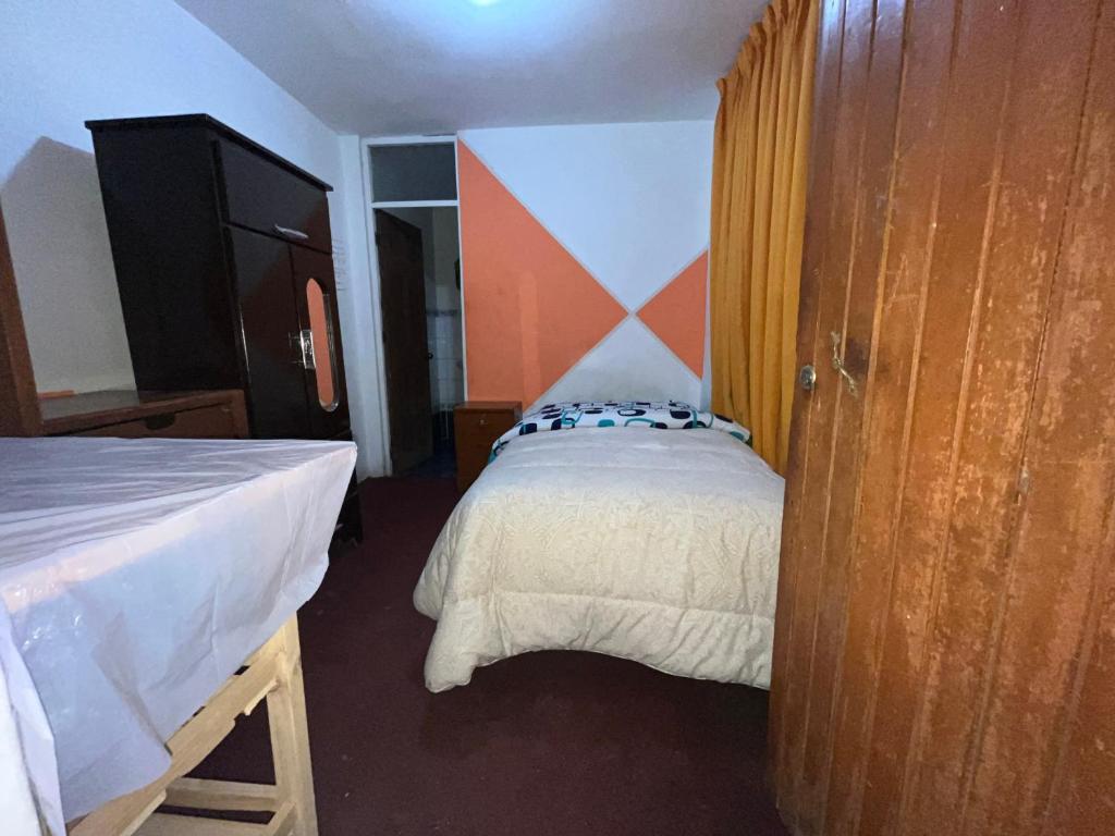 Habitación pequeña con cama y cortina en Villa el sol en Cajamarca