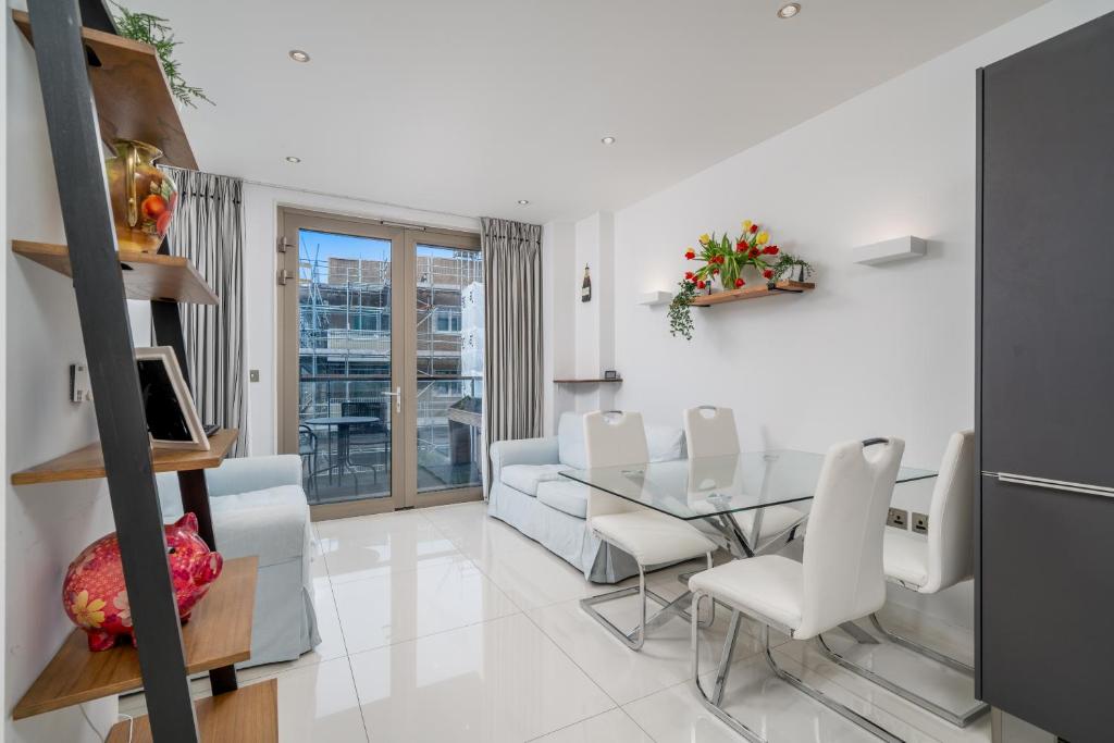 a living room with a glass table and white chairs at Fantastic flat near Tower Bridge in London