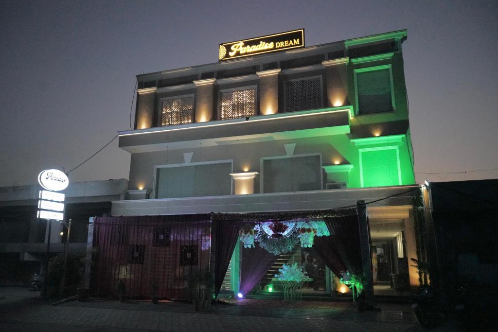 un edificio verde con un cartello sopra di Hotel Paradise Dream a Ludhiana