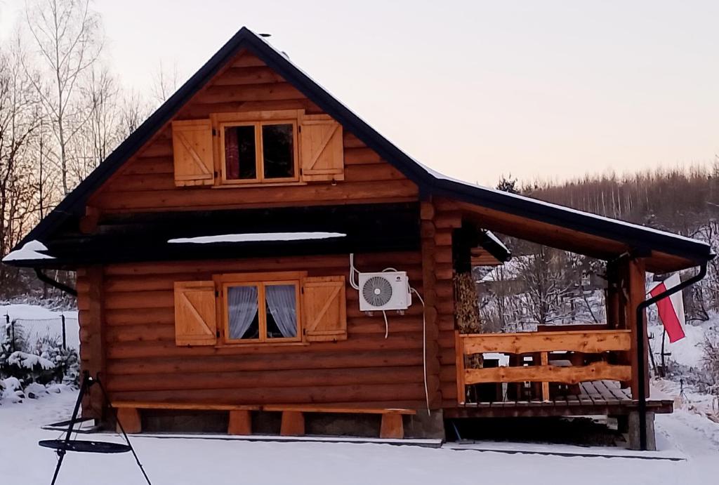 a log cabin in the snow with at Siedlisko Sielska Dolina Nad Stawem luksusowy domek całoroczny z klimatyzacją 