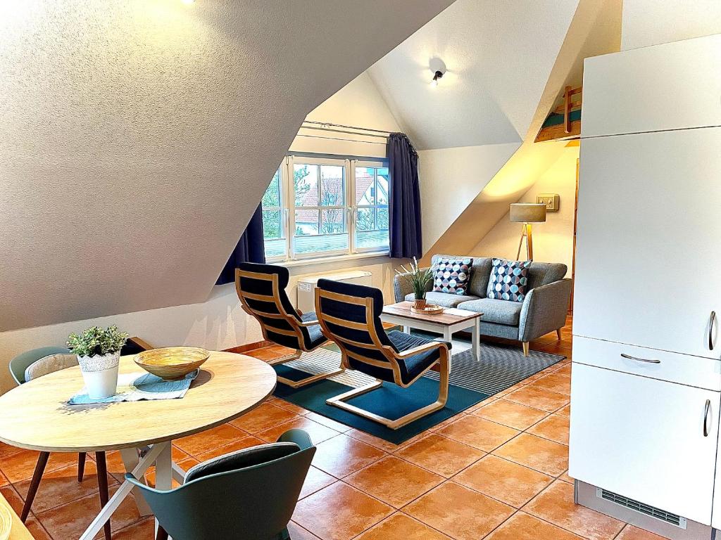 kuchnia i salon ze stołem i krzesłami w obiekcie Ferienhäuser Liethmann Haus 3 W2 w mieście Timmendorfer Strand