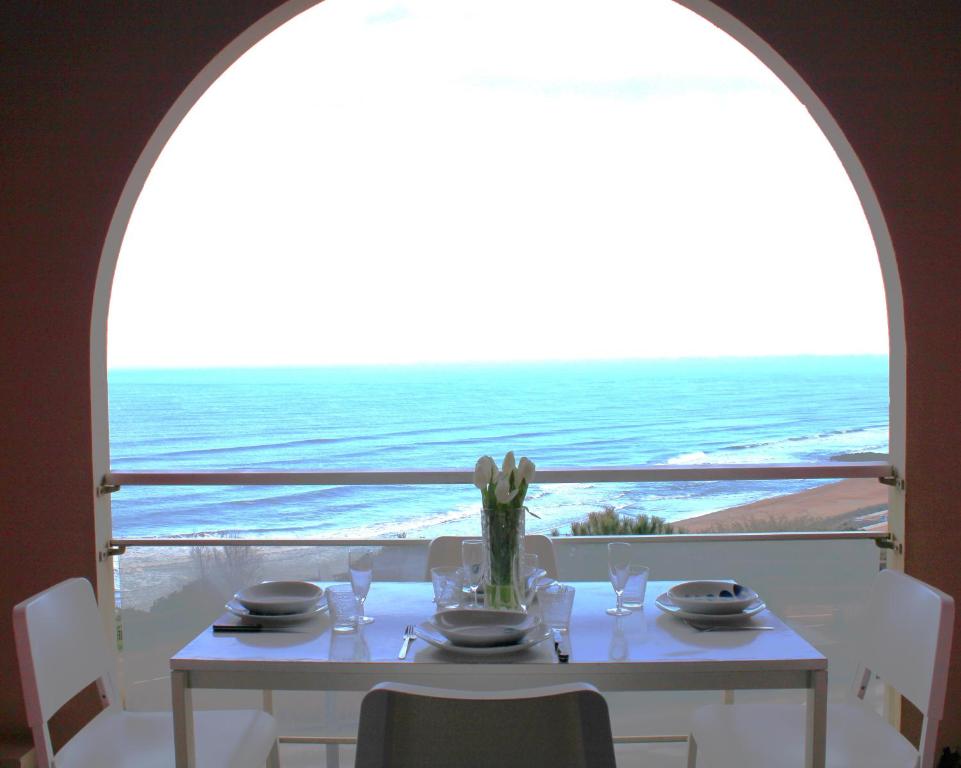 - une table à manger avec vue sur l'océan dans l'établissement Duplex vue Océan- Piscine-Plage à pied, à Anglet