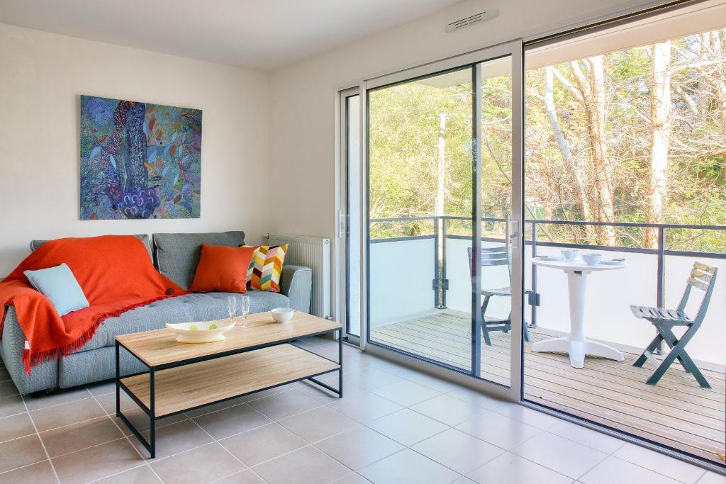 un salon avec un canapé et une table dans l'établissement 1km de la plage des Sables Blancs- Concarneau à 2, à Concarneau
