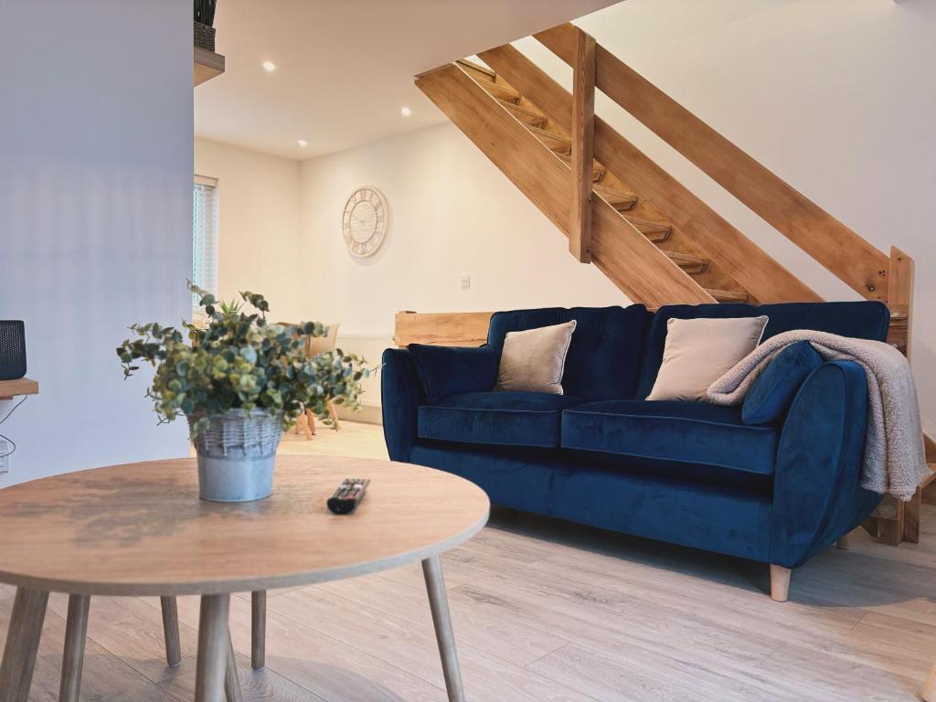 23 Coastal Comfort في ميلوم: غرفة معيشة مع أريكة زرقاء وطاولة
